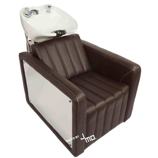 Shampoo backwash hair washing unit with cocoa vinyl, reflective chrome arms, and a white ceramic bowl. Built to be both appealing to the eye and sturdy, this shampoo chair is sure to meet the needs of any salon stylist.